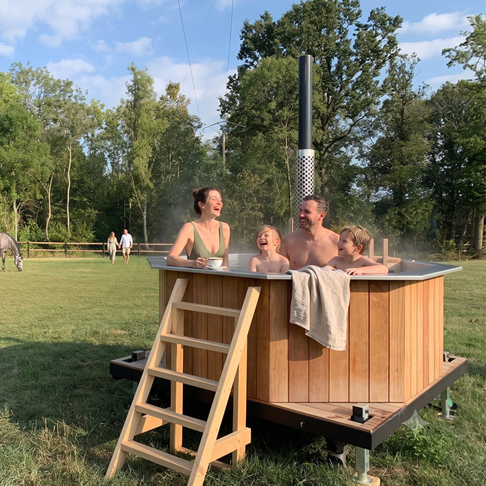 photo-famille-dans-spa bain nordique avec famille dans un champ avec des chevaux